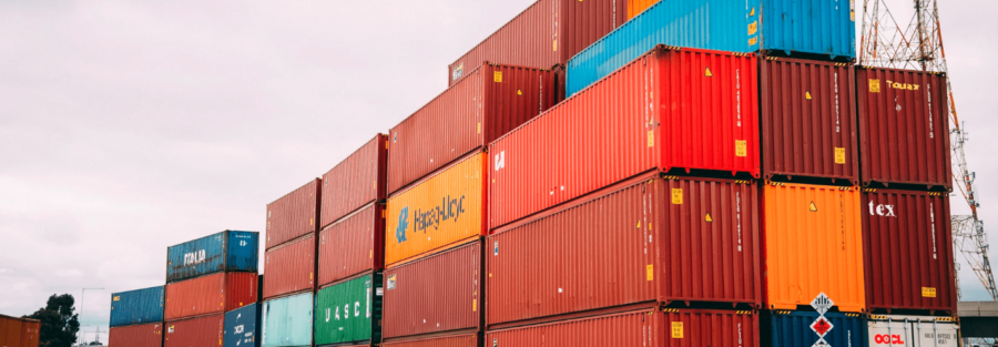Stacked shipping containers at a cargo terminal for international freight, export, import, and global logistics operations.